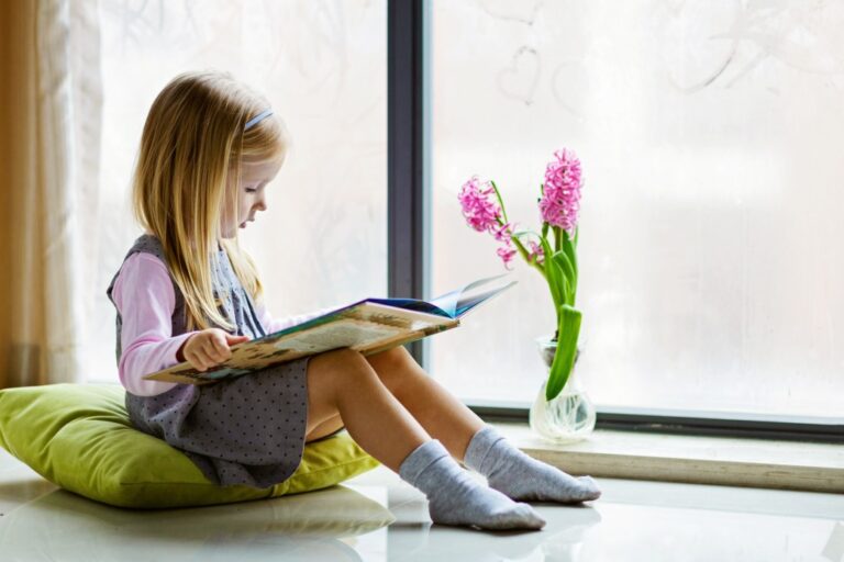 nominated-cute-little-girl-with-blonde-hair-reading-book-on-balcony-at ...