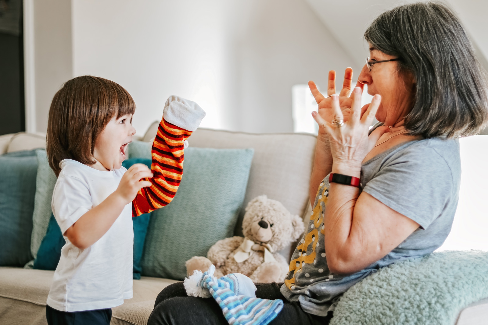 Grandmother plays sock puppet game with toddler