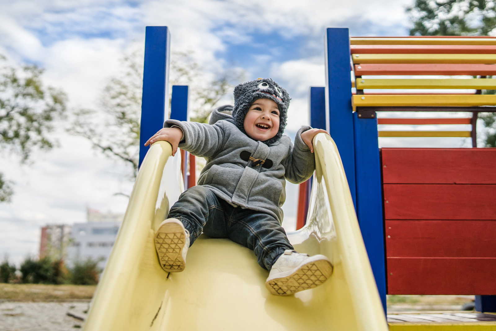 Child slides on playground on a cold winter day